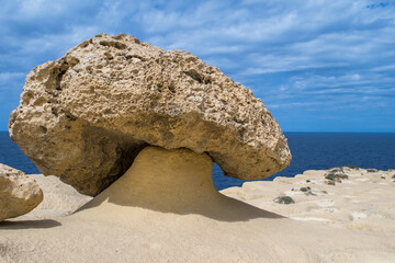 A mushroom shaped rock or rock pedestal, formed by erosion of soft and hard rock in Gozo, Malta