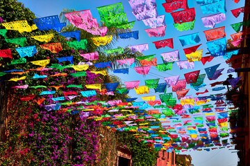 calle colorida con adornos de papel de colores en un día soleado en san miguel de allende guanajuato