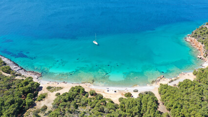 Aerial drone photo of beautiful sail boat anchored in Aegean island paradise bay with turquoise sea