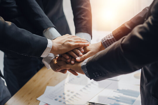 Business people putting their hands together. Stack of hands and together working on new startup project. Unity and teamwork concept.