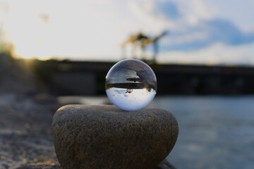 Reflective glass ball on a rock near a power plant