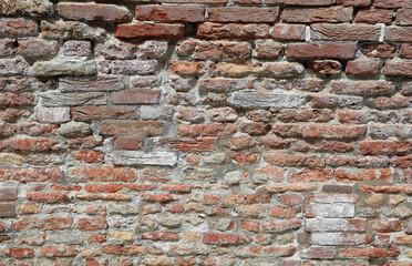 wall of red bricks with traces of humidity and salt caused by exposure to natural elements