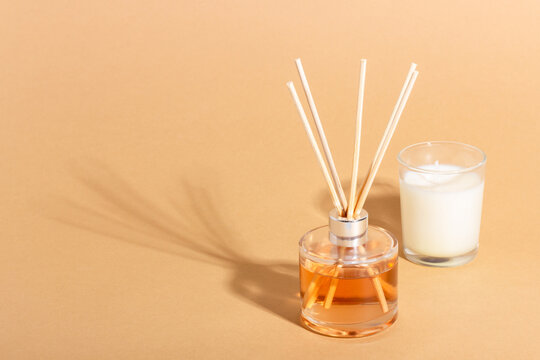 reed diffuser bottle on a beige background. Incense sticks for the home with a floral scent. The concept of eco-friendly fragrance for the home