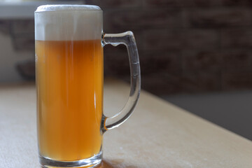 Mug of cold foamy beer close-up.