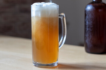 Pouring beer into a glass pint placed on a tree