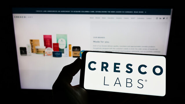 Stuttgart, Germany - 03-28-2022: Person holding cellphone with logo of US cannabis company Cresco Labs Inc. on screen in front of business webpage. Focus on phone display.
