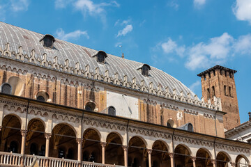 Fototapeta premium The scenic view from Piazza delle Erbe on the loggia which is the external balcony of Palazzo della Ragione in Padua, Veneto, Italy, Europe. Light beams on beautiful colonnade with column architecture