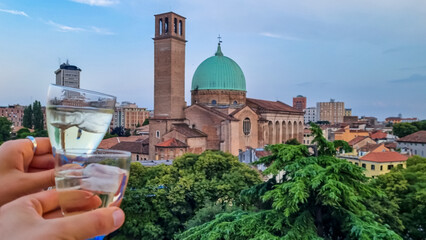 Couple clinking glasses full of champagne with scenic view from luxury hotel balcony on Basilica di...