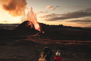 Evening view of the volcano eruption in Iceland. People are watching the fiery river