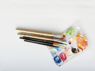 Multi-colored strokes, paint residues on the brushes and palette after painting. Close-up on a...