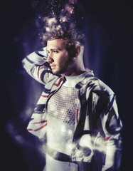 Fantasy glowing particles portrait of a young man with lens blur glow effect. Fashion trendy studio...