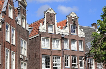 Fototapeta na wymiar Amsterdam Begijnhof Courtyard Historic Brick House Facades with Neck Gables Close Up, Netherlands