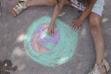 chile is painting easter egg with chalk on a sidewalk 