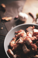 Fried Pork Belly with Fish Sauce Served on a Gray plate on a black wooden floor.