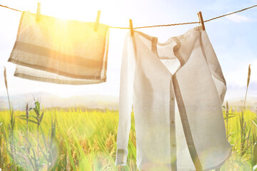 White clothes hanging backlit outdoors with sunny landscape background - Powered by Adobe