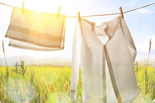 White clothes hanging backlit outdoors with sunny landscape background