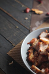 Fried Pork Belly with Fish Sauce Served on a Gray plate on a black wooden floor.