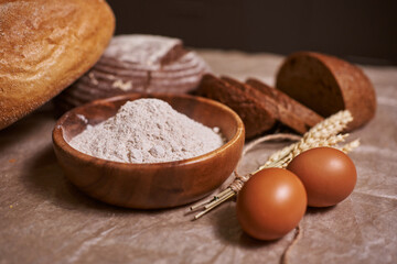 Whole wheat bread with bio and organic ingredients, healthy with seeds, sesame and grains. Bread, eggs, flour background