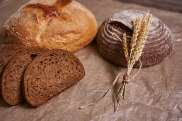 Creative background, freshly baked sliced rye bread on a wooden cutting board, flat lay, copy space. The concept of fresh pastry, black bread.