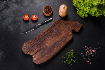 A wooden cutting board with a kitchen knife with spices and herbs
