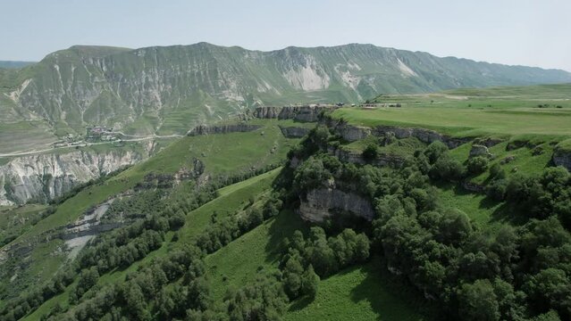 Beautiful green mountains. Action. Landscape of large summer mountains over which there is a light blue sky.
