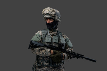 Studio shot of isolated on gray background soldier dressed in camouflage clothes.