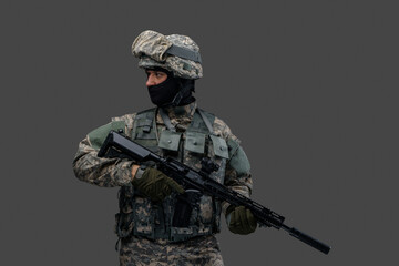 Studio shot of isolated on gray background soldier dressed in camouflage clothes.