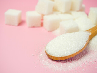 granulated sugar and sugar cubes on a pink background with space for text