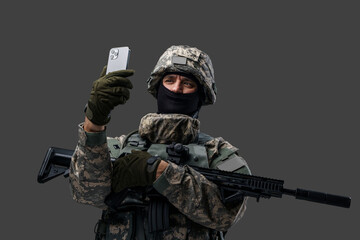 Portrait of cheerful soldier from ukraine dressed in protective uniform with cellphone. Information...