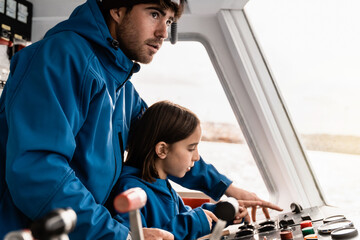Father and daughter sailing a boat together having fun during vacation time - Focus on man face