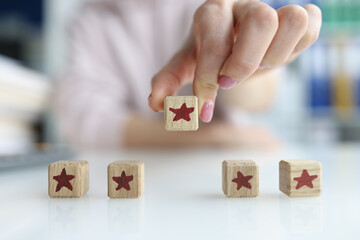 Hands of customer holding cube wooden block with five star vote rating