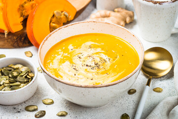 Pumpkin soup puree with cream in the craft bowl. Close up.