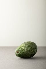 Avocado on grey background, space for text