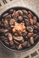 Cocoa beans and chocolate truffles in bowl. Sweet pralines.