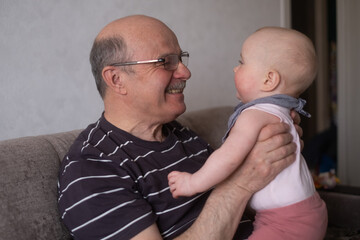 Grandfather holding a caucasian 8 month baby girl