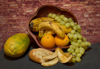 Still life of papaya oranges grapes banana and bread