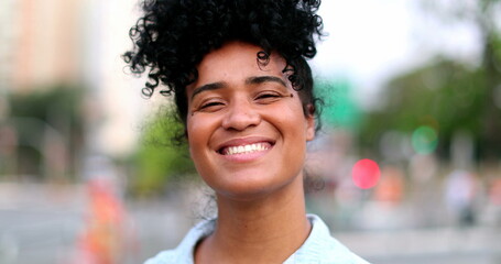 Brazilian woman smiling at camera in urban city in background