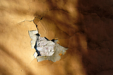 Texture old wall with wood shadows and peeling paint and hole
