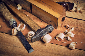 Set of tools for carpenters, hammer, chisel and plane on wooden background.