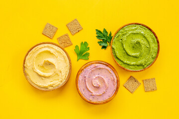 Various types of hummus in bowls. Hummus with spinach and beets