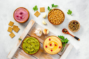 Various types of hummus in bowls. Hummus with spinach and beets
