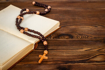 Rosary beads with cross on Bible book. Faith and prayer concept
