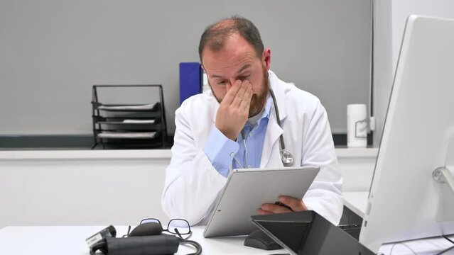 Doctor looking worried a x-ray image at digital tablet, checking the results of a medical examination. High quality 4k footage