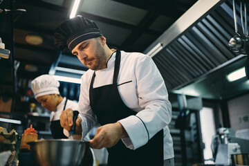 Professional male cook preparing food at restaurant kitchen.