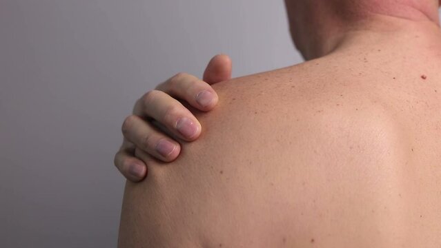 Shoulder pain and trigger points. Naked man closeup massaging painful shoulder. Joint injuries. Health care, medical treatment concept.