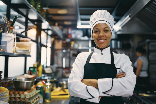 Portrait of confident black female chef at restaurant kitchen looking at camera.