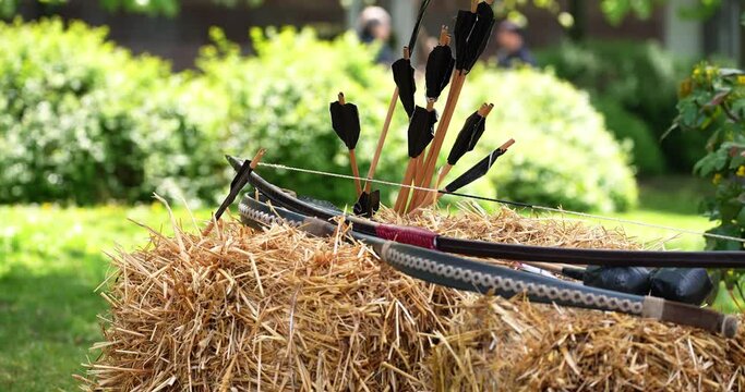 a bow and arrow leaning on a haystack outside