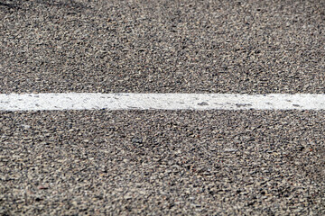 Asphalt background with white road marking line close-up