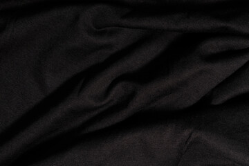 Fototapeta na wymiar Dark background of black, wavy fabric texture