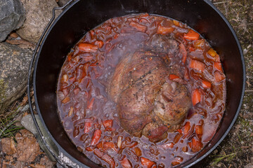 Game meat with vegetables in the durch oven, campfire cooking